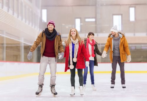 2 women and 2 men ice skating and holding hands