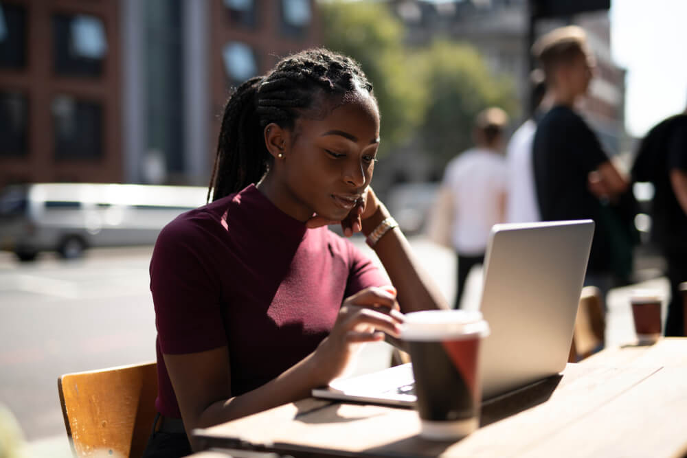 Girl with maroon shirt working at one of the best cafes for studying London 