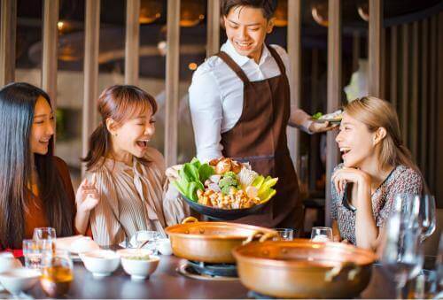 3 girls being served food at a restaurant 