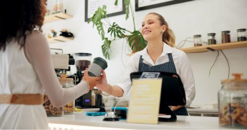 Person handing out a coffee near the till 