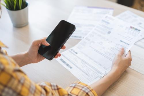 Girl holding a bills and a phone 