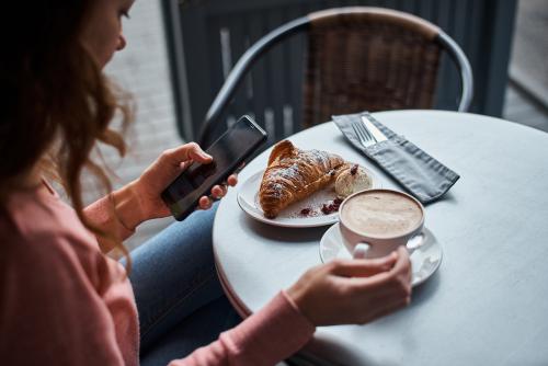 Girl having coffee and croissant at a cafe