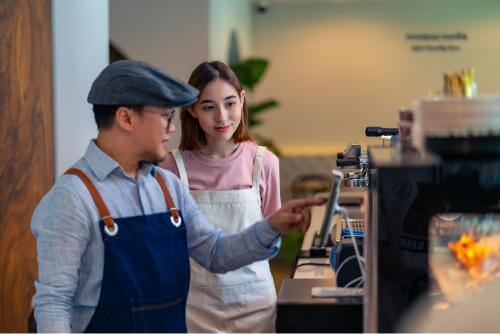 Employee teaching the new student how to use the machine