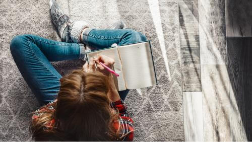 Girl writing on a book 